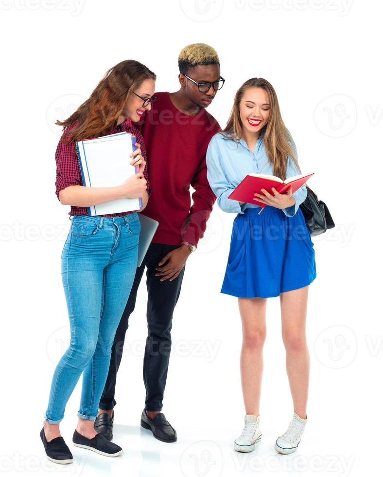 Happy students standing and smiling with books, laptop and bags isolated on white photo