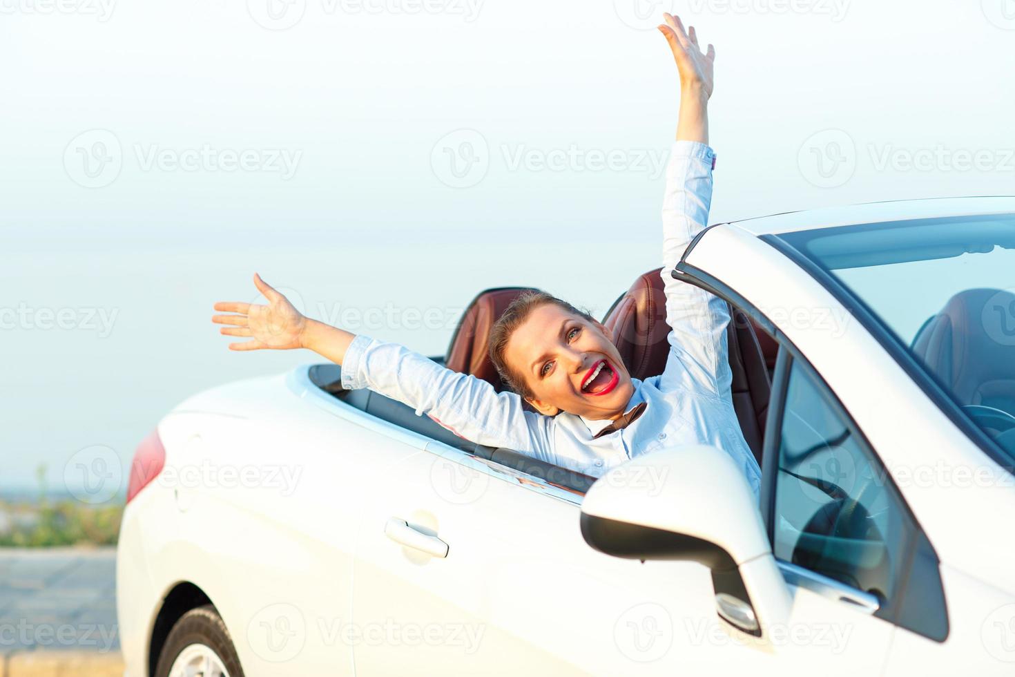 Freedom - happy free woman in cabriolet cheering joyful with arms raised photo