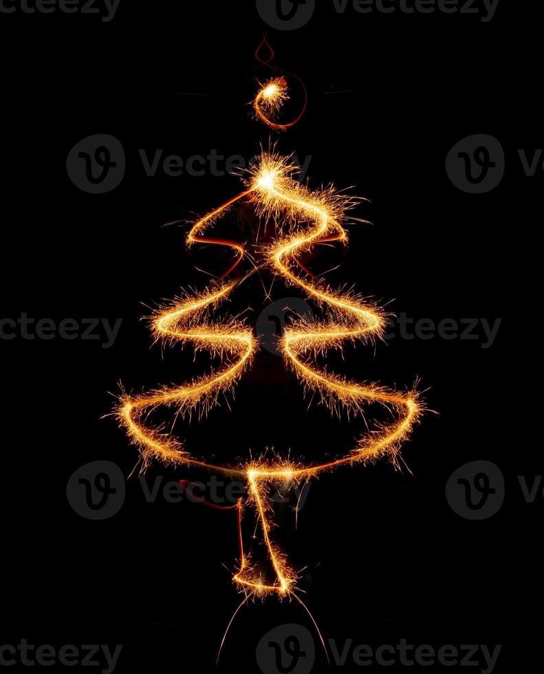 Christmas tree made by sparkler on a black photo