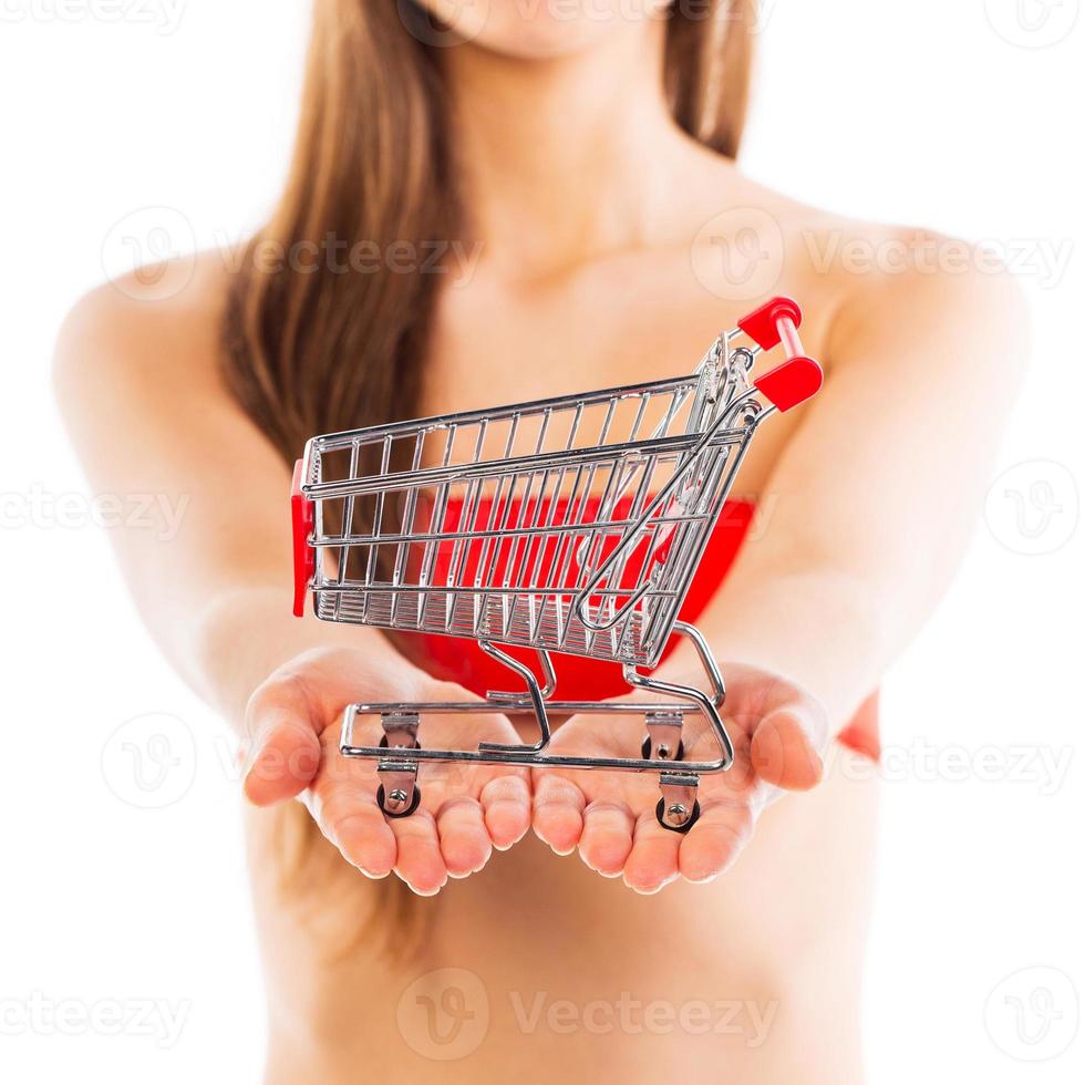 Beautiful Santa christmas girl with small shopping trolley on white photo