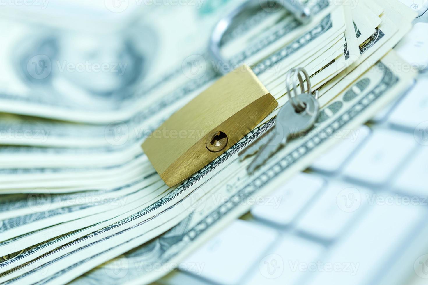 Security lock on dollar bills with white computer keyboard photo