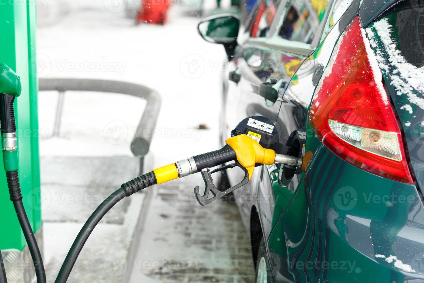 coche repostaje en un gasolina estación en invierno foto