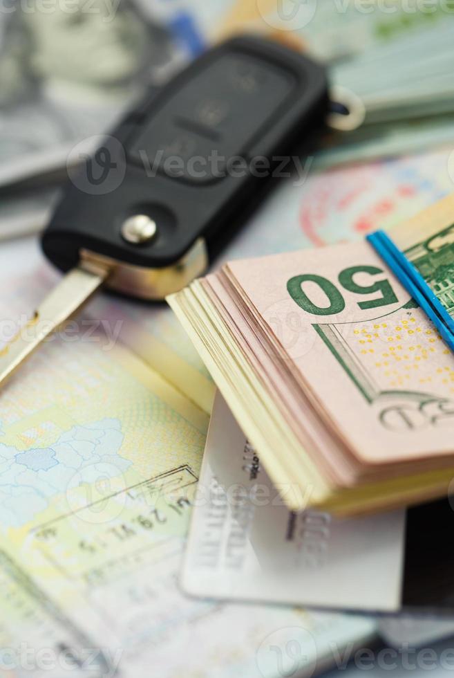 American money, credit cards and car key lies on thr top of the opened passport photo