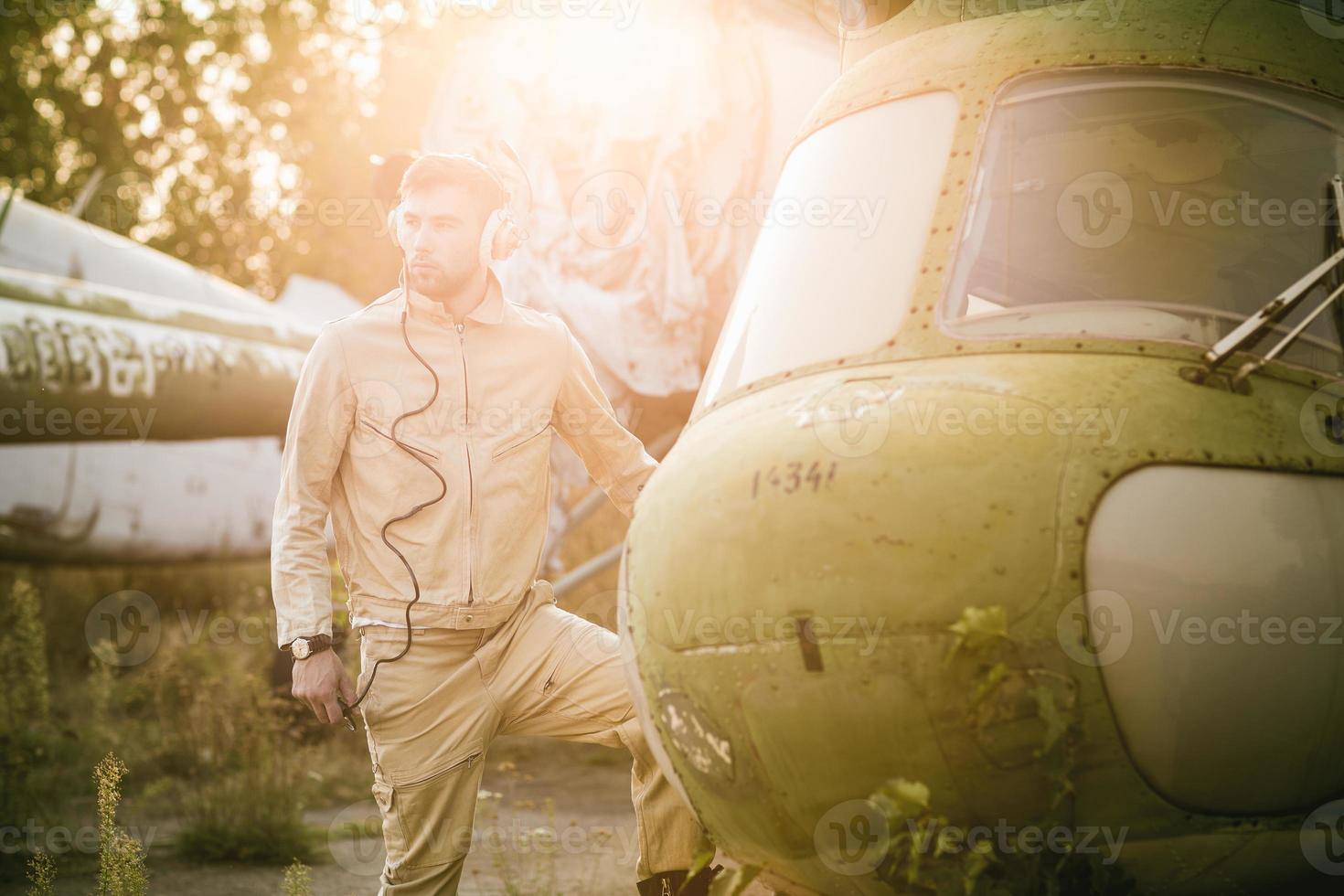 Young pilot posing near the helicopter photo