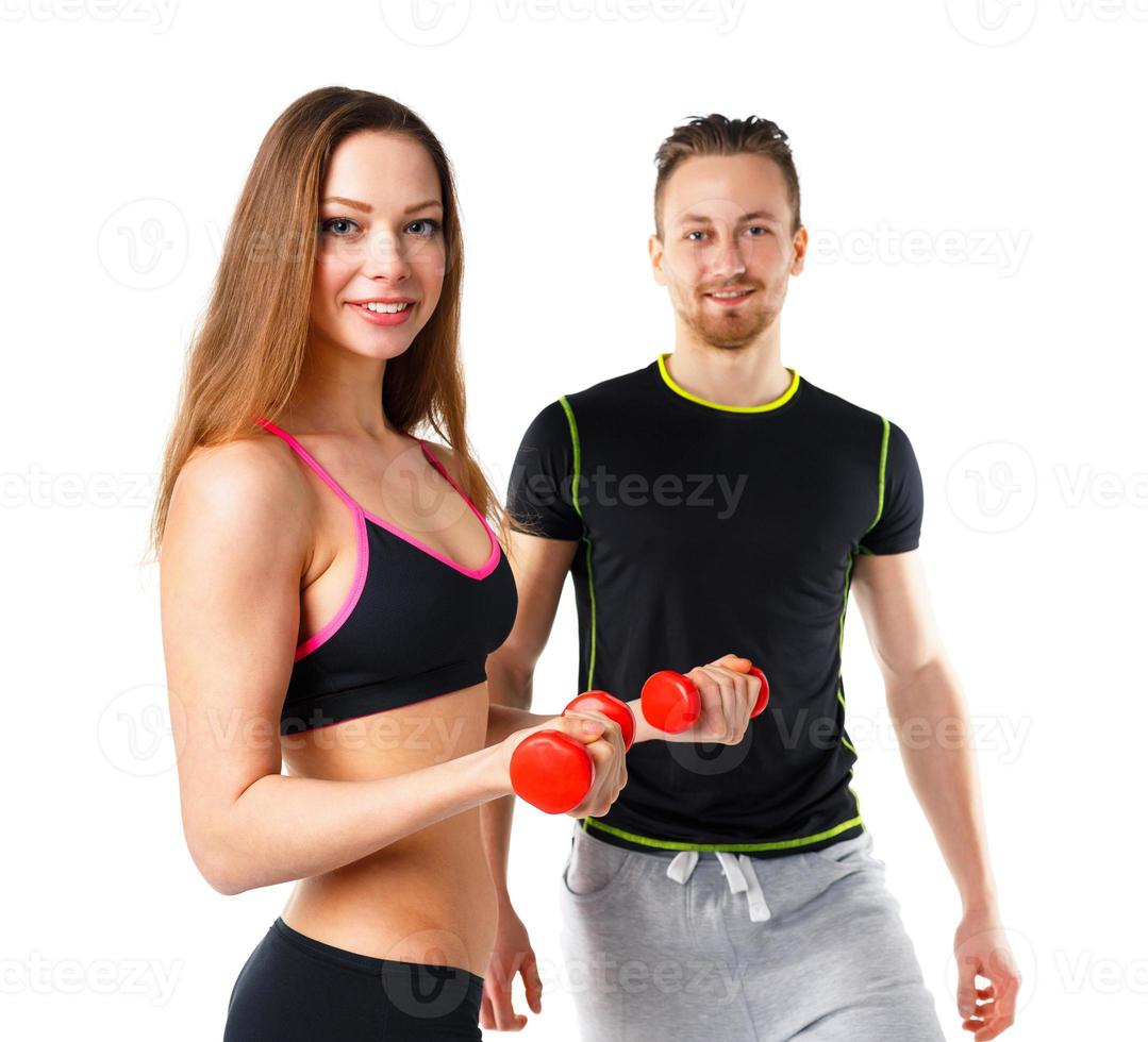 Athletic man and woman with dumbbells on the white photo