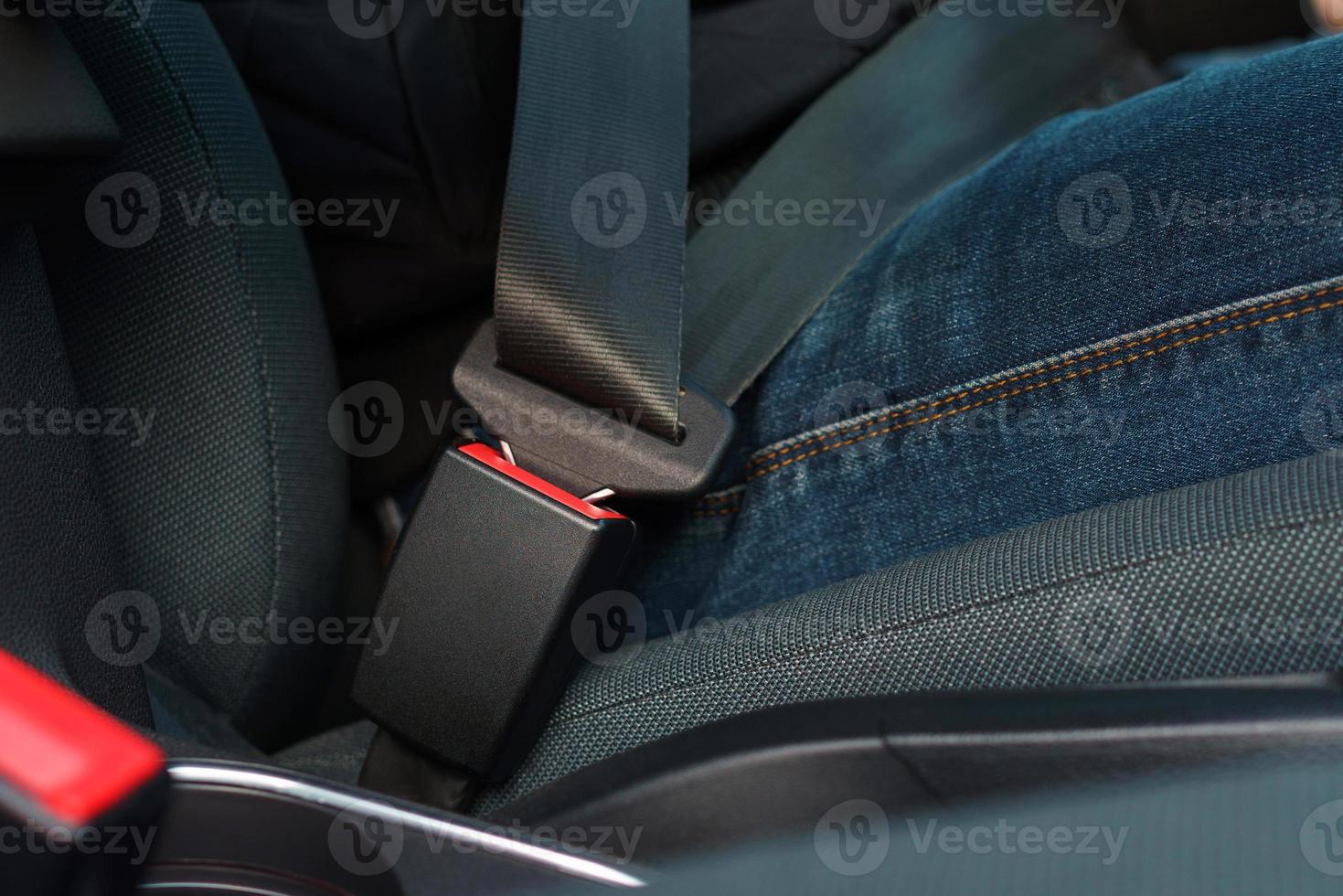 Male hand fastening car safety seat belt while sitting inside of vehicle before driving photo