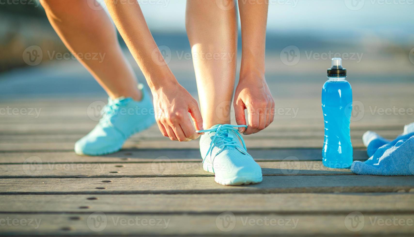 Running shoes - woman tying shoe laces photo