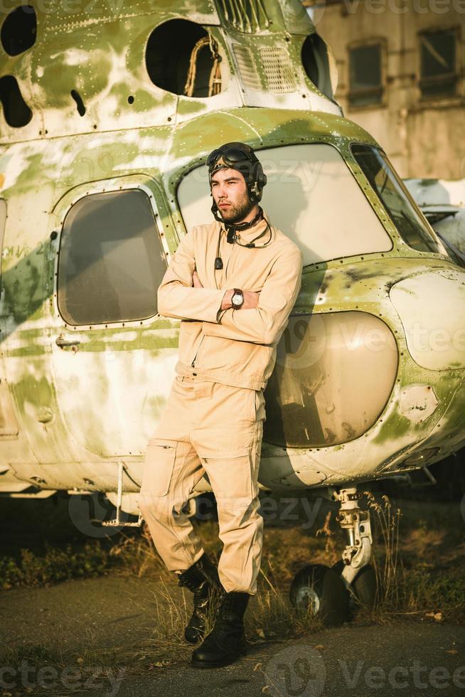 joven piloto posando cerca el helicóptero foto