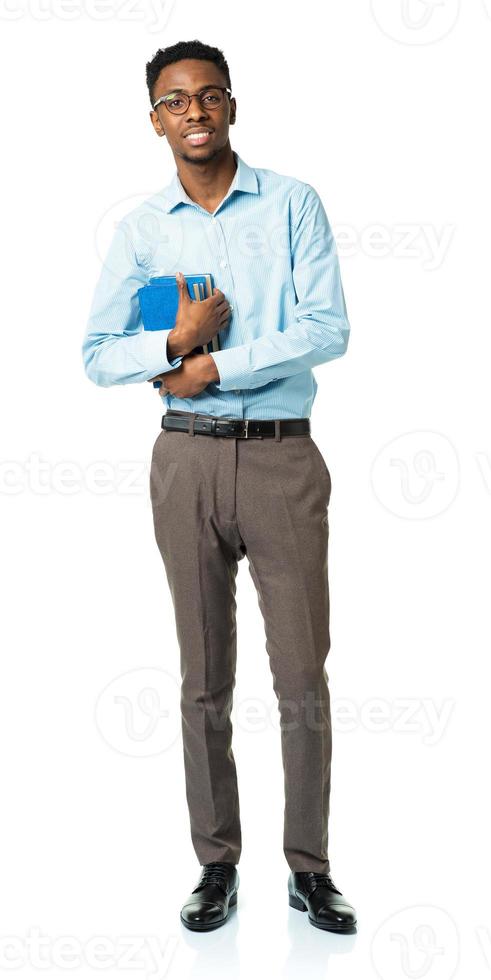 Happy african american college student standing with books in his hands on white photo