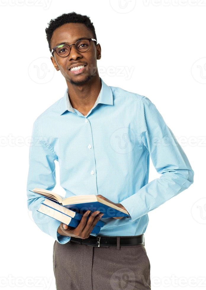 Happy african american college student standing with books in his hands on white photo