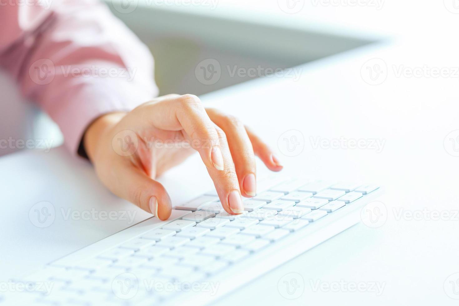 Woman office worker typing on the keyboard photo