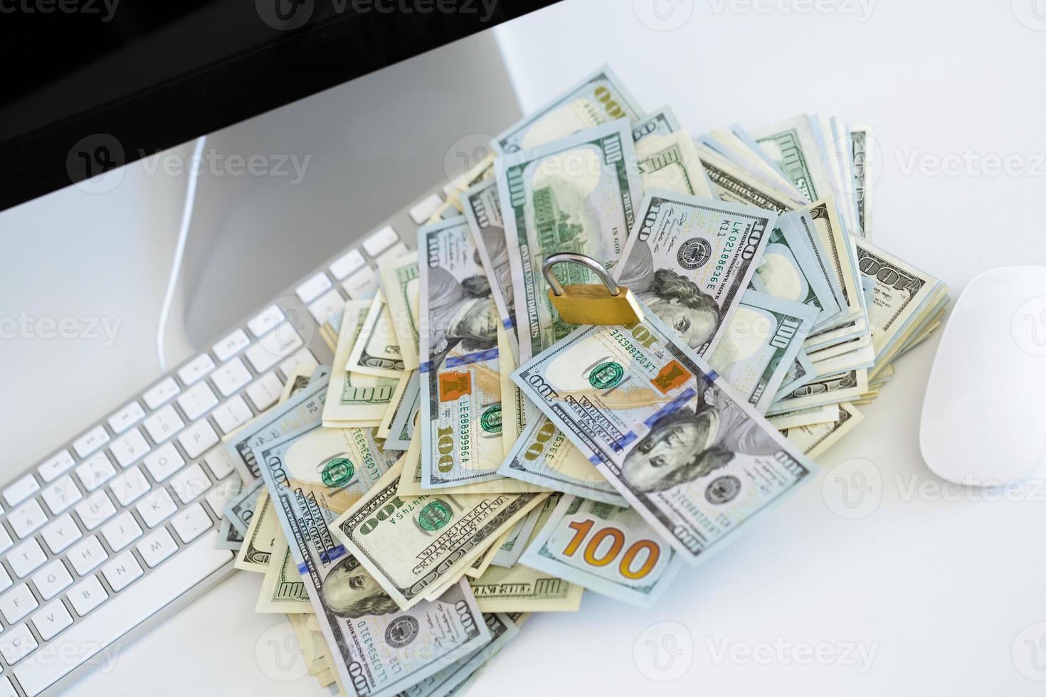 Security lock on dollar bills with white computer keyboard photo