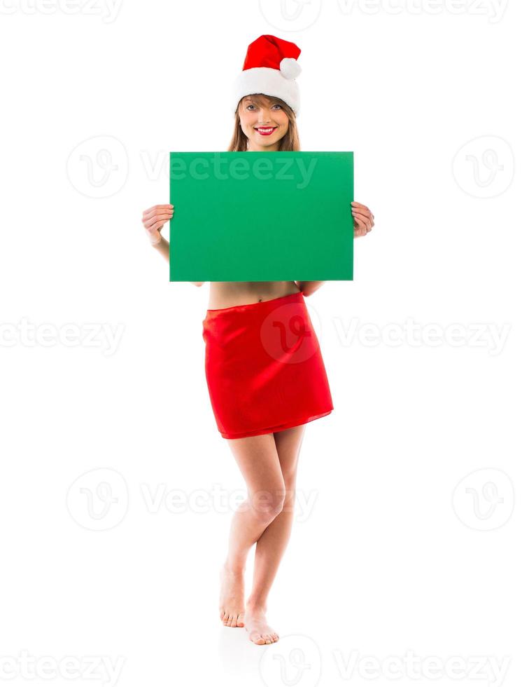 Smiling christmas girl with green placard on white photo
