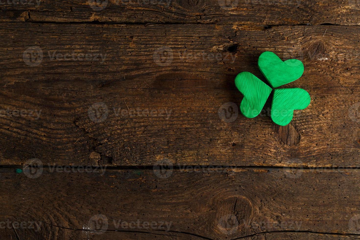 Green shamrock clovers on wooden background photo