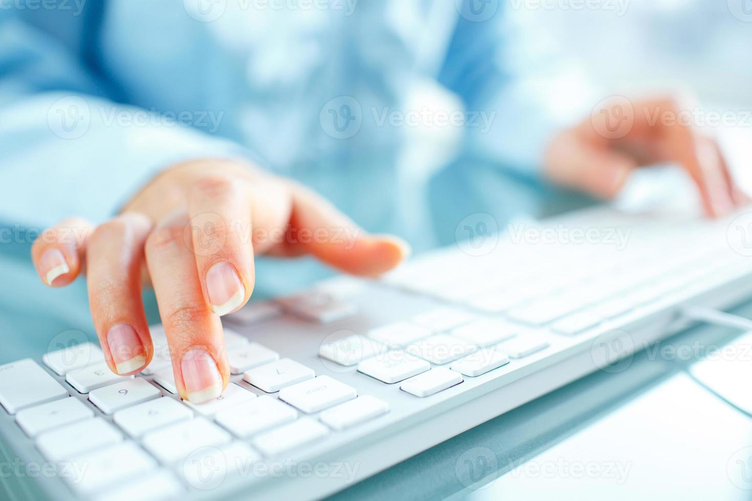 Woman office worker typing on the keyboard photo