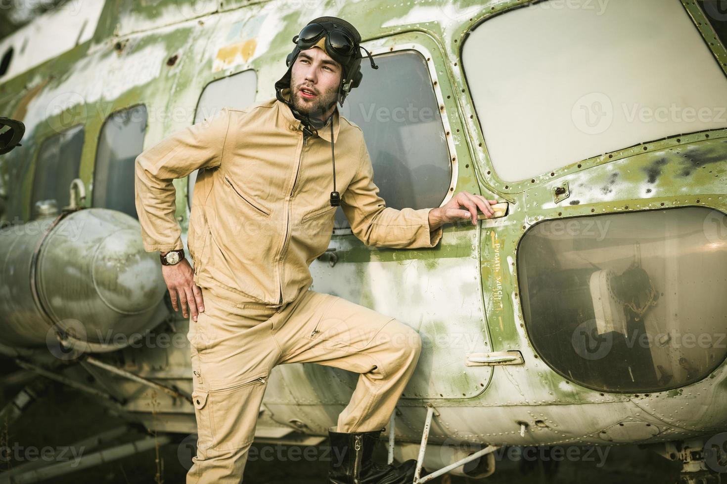 Young pilot posing near the helicopter photo