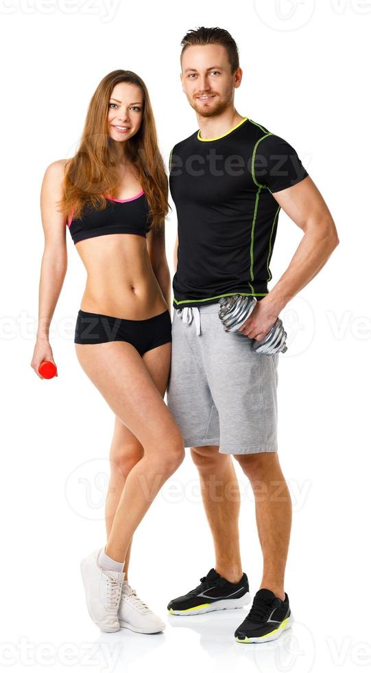 Sport couple - man and woman with dumbbells on the white photo
