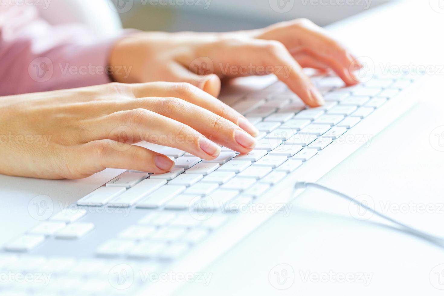 Woman office worker typing on the keyboard photo