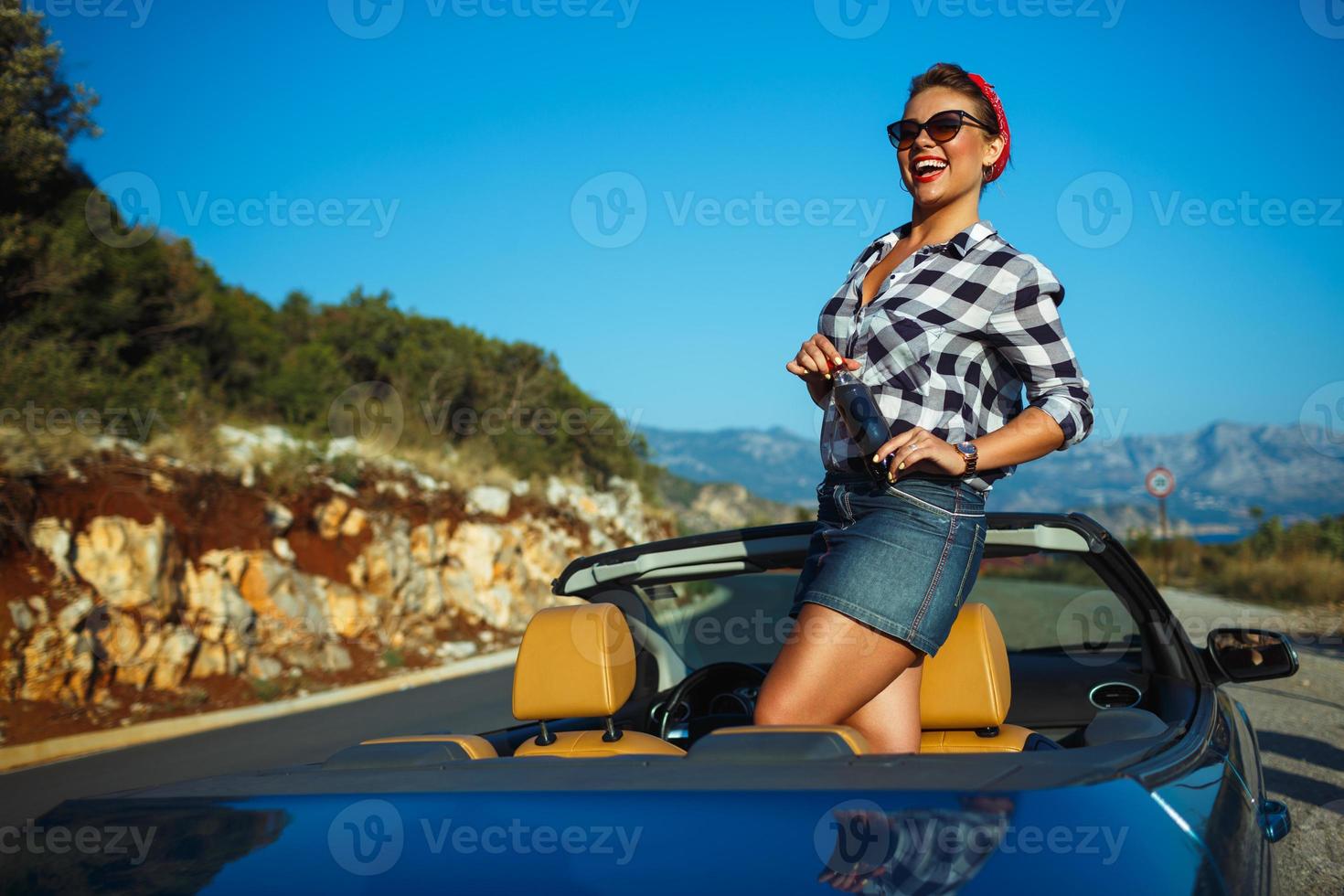 hermosa alfiler arriba mujer sentado en cabriolé, disfrutando viaje en lujo moderno coche con abierto techo foto