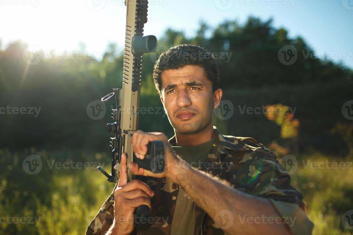 Man of Arab nationality in camouflage with a shotgun photo