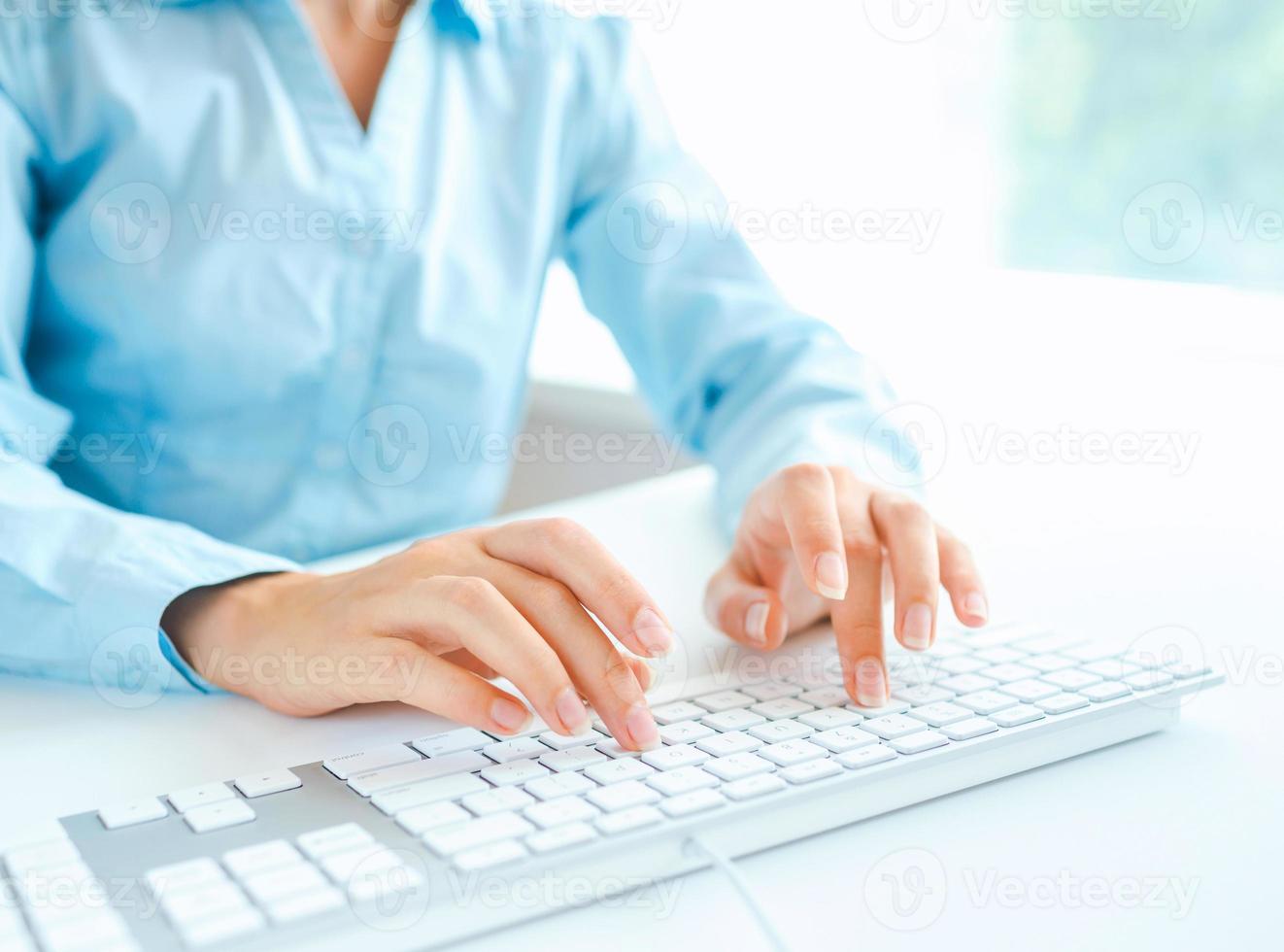 Woman office worker typing on the keyboard photo