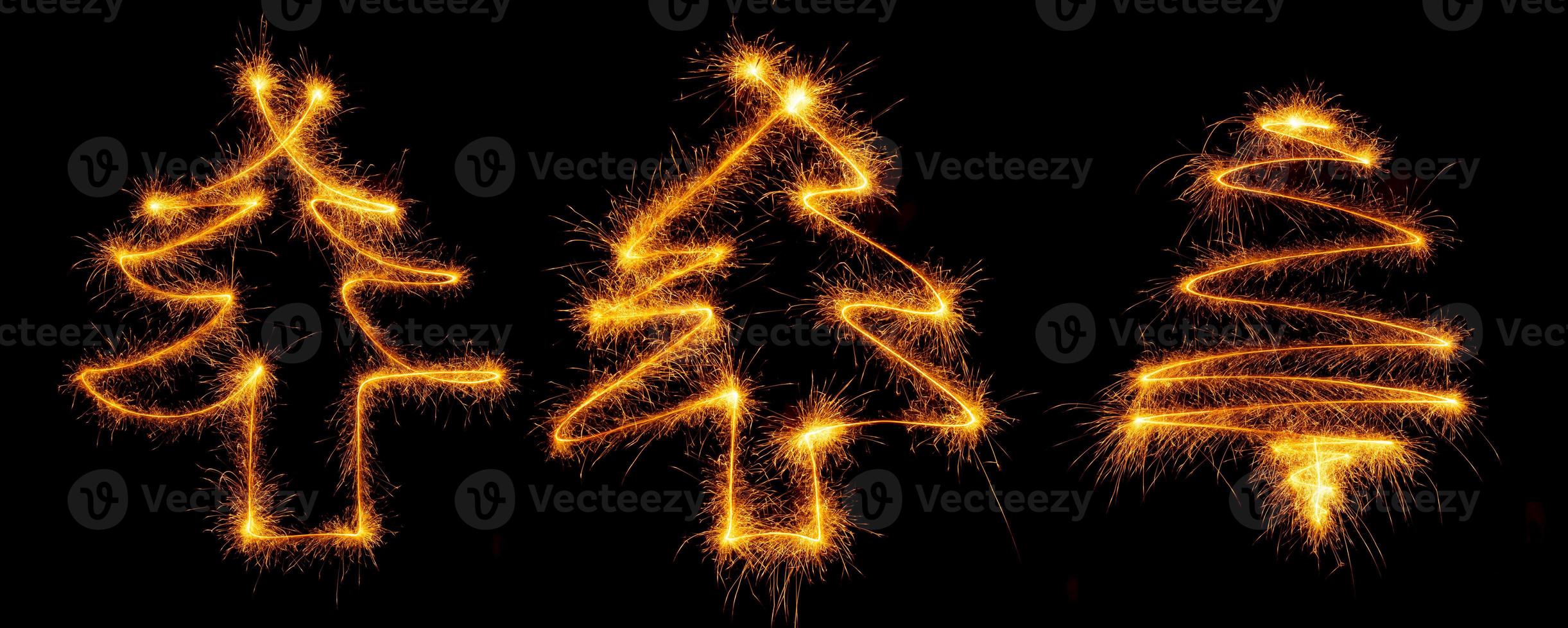 Three christmas tree made by sparkler on a black photo