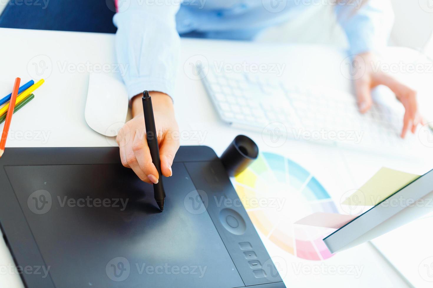 Graphic designer drawing something on graphic tablet photo