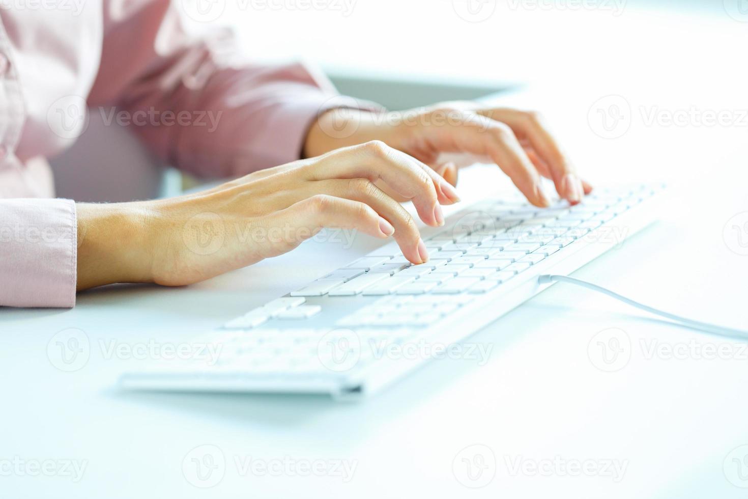 Woman office worker typing on the keyboard photo