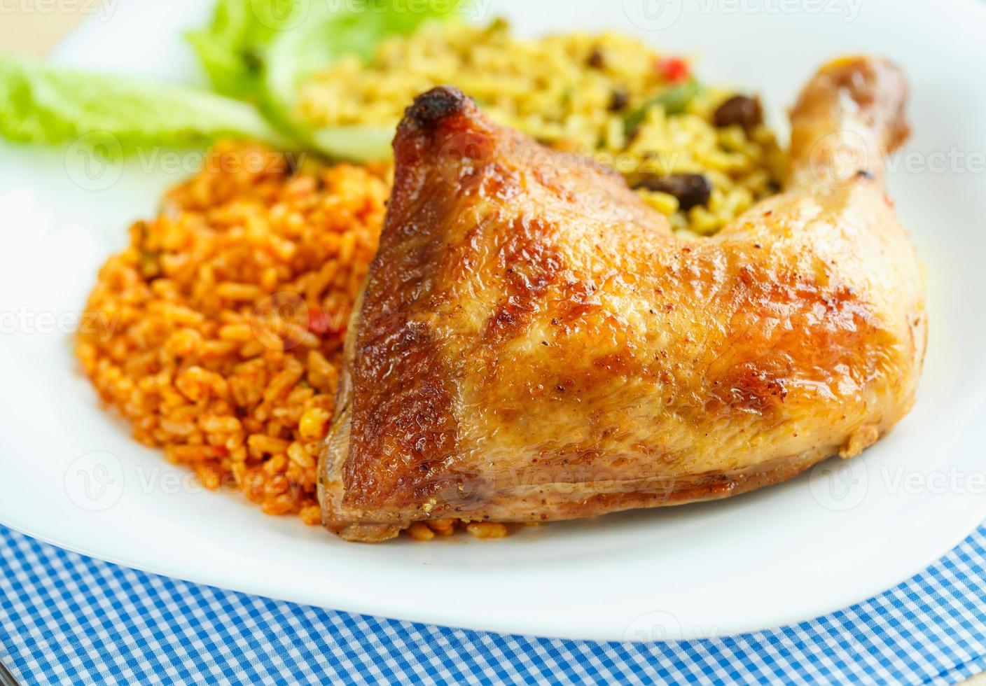 Delicious dish of chicken thigh with rice and salad leaves photo