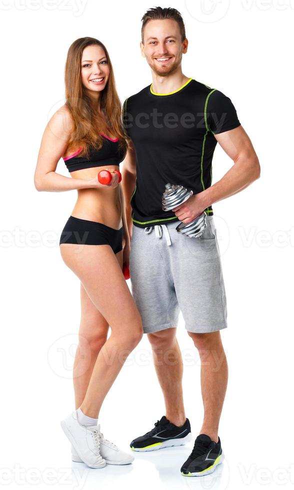Athletic man and woman with dumbbells on the white photo