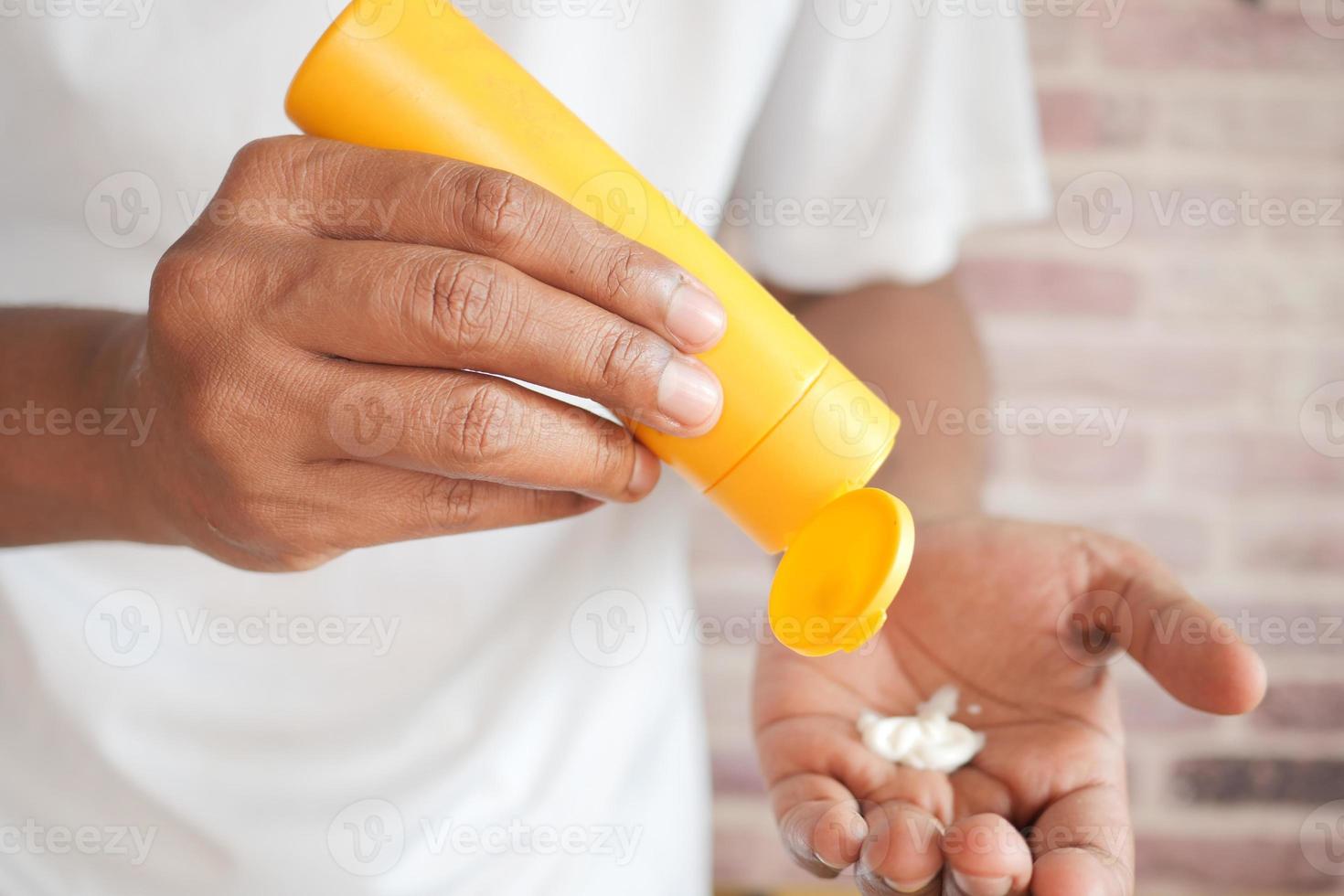 young men using sunscreen cream photo