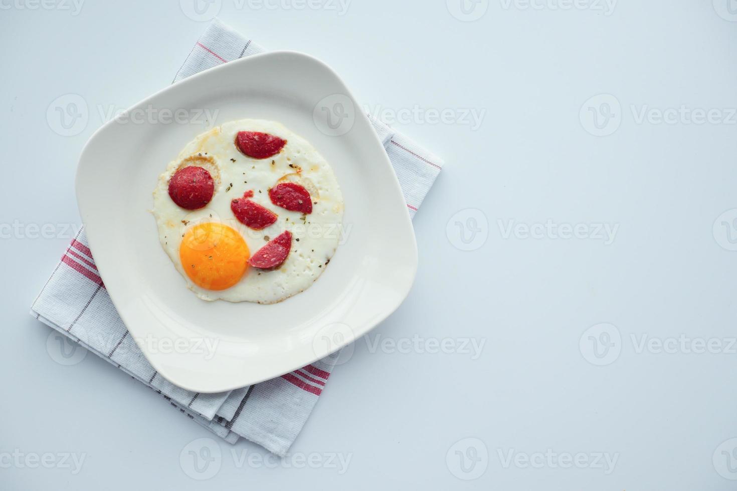 Fried eggs with sausage on table photo