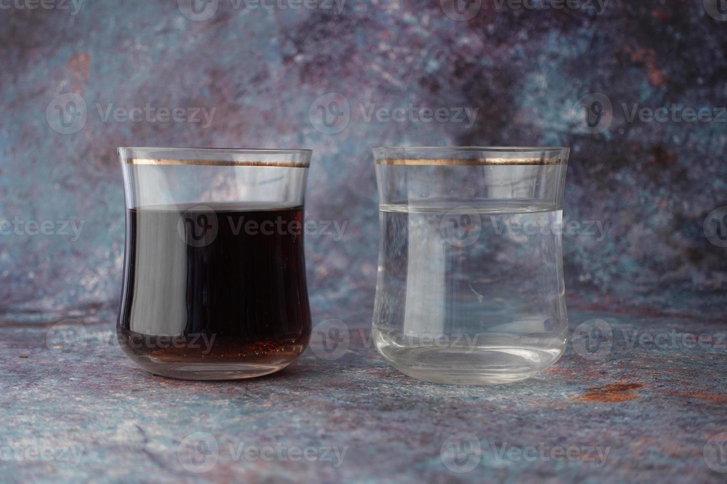 comparing soft drinks and glass of water on table photo