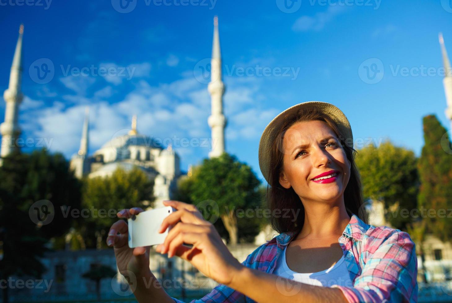 Girl making selfie by the smartphone on the background of the Blue Mosque, Istanbul. Turkey photo
