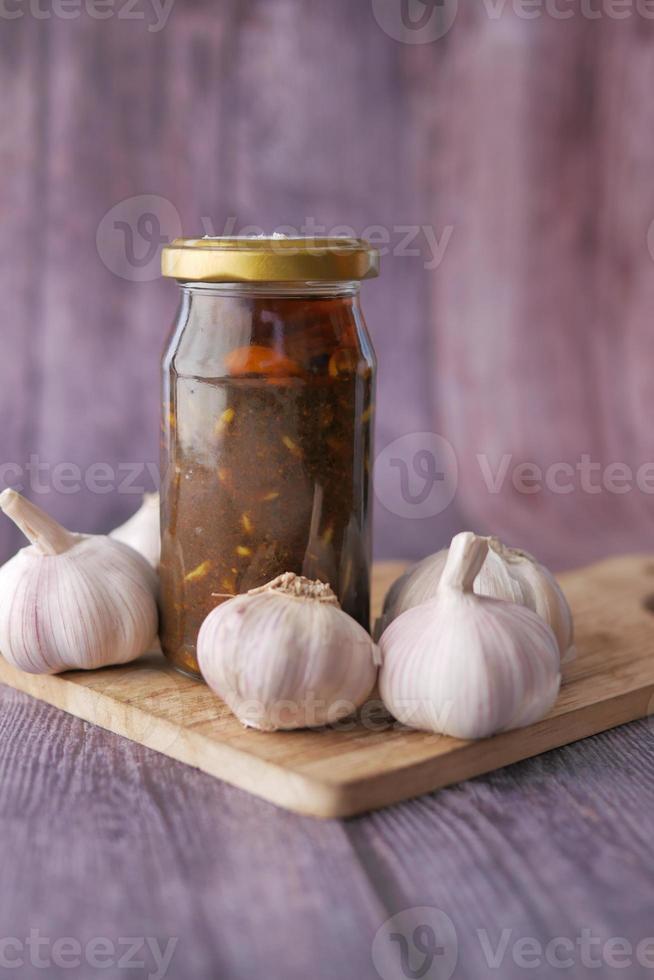 Homemade Garlic Pickle in a glass jar on table , photo