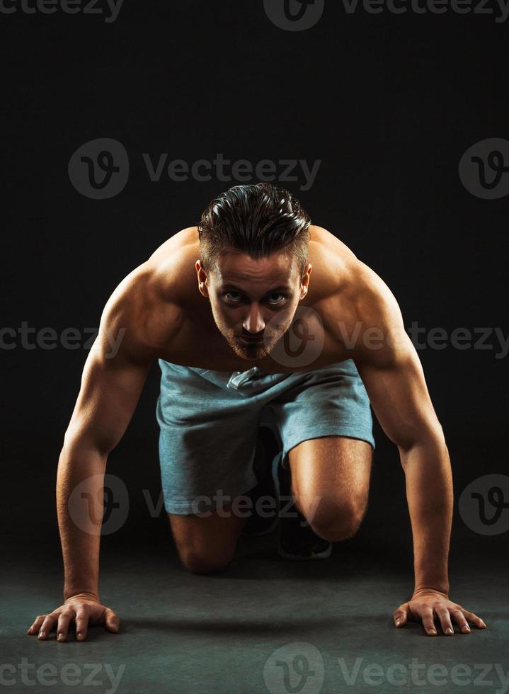 Sport attractive man doing fitness exercises on the black photo
