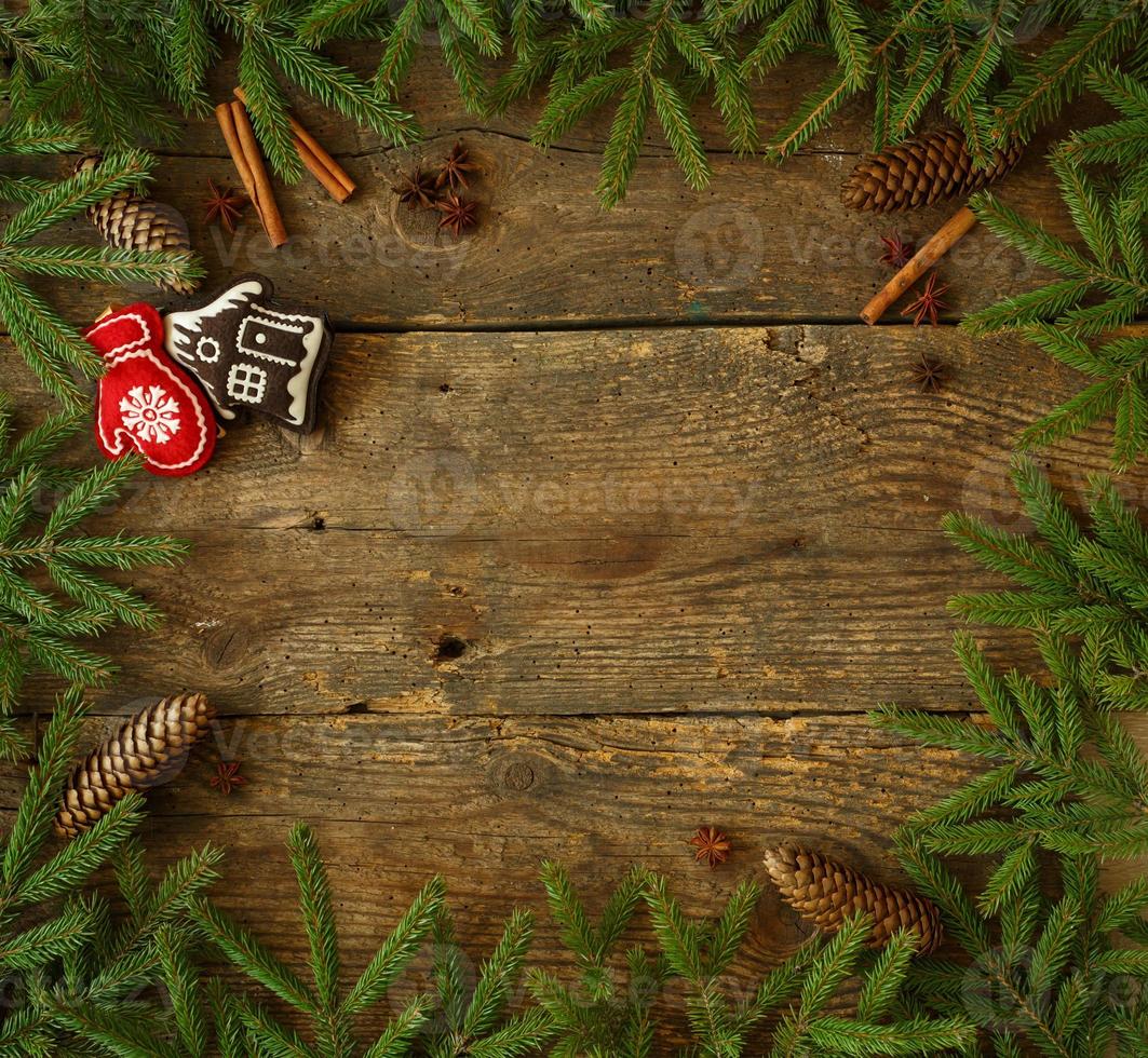 Christmas tree branch with cones, cinnamon, dittany and christmas decorations on wooden background with copyspace photo