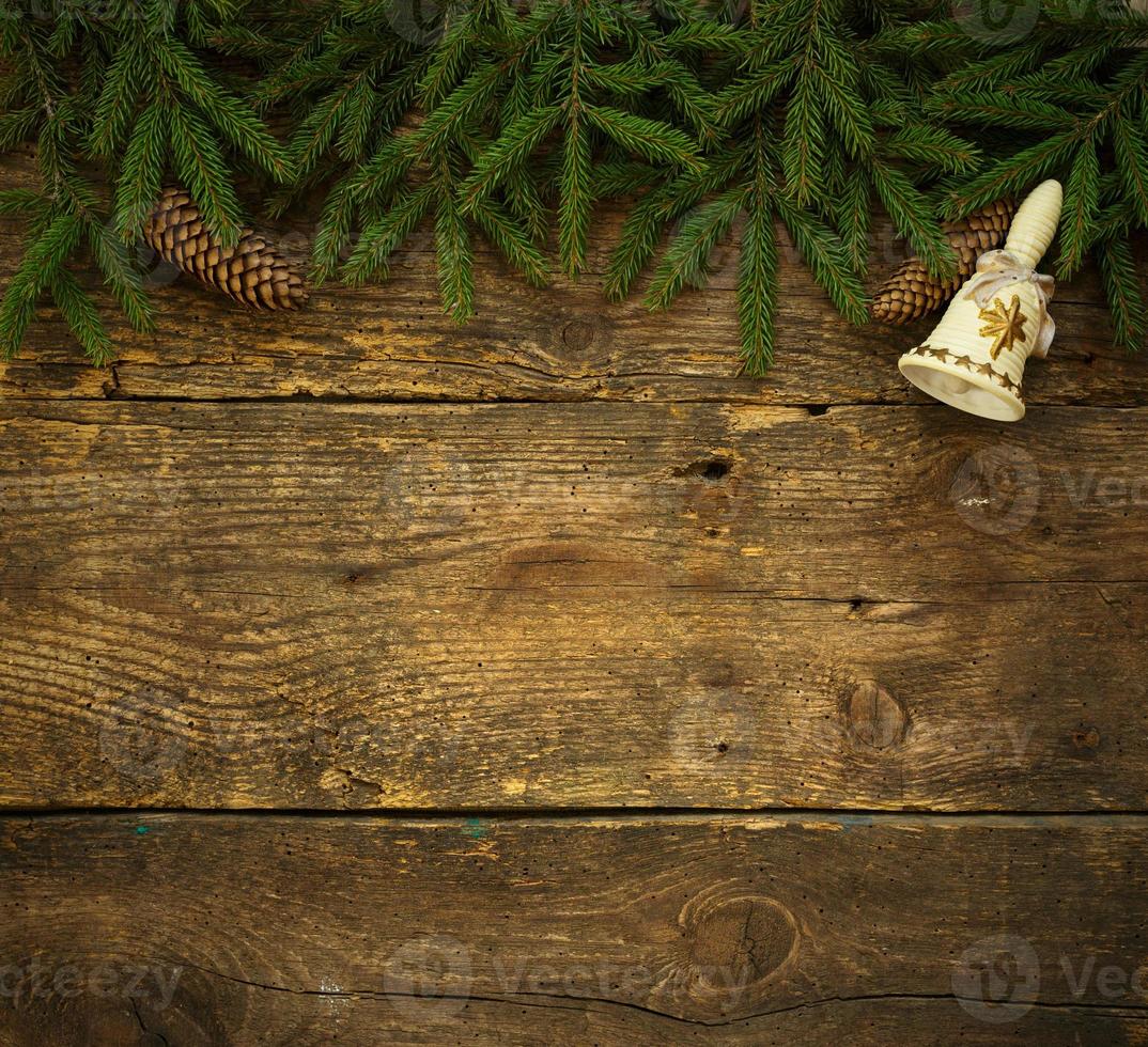 Christmas tree branches with cones and christmas decorations on wooden texture ready for your design photo