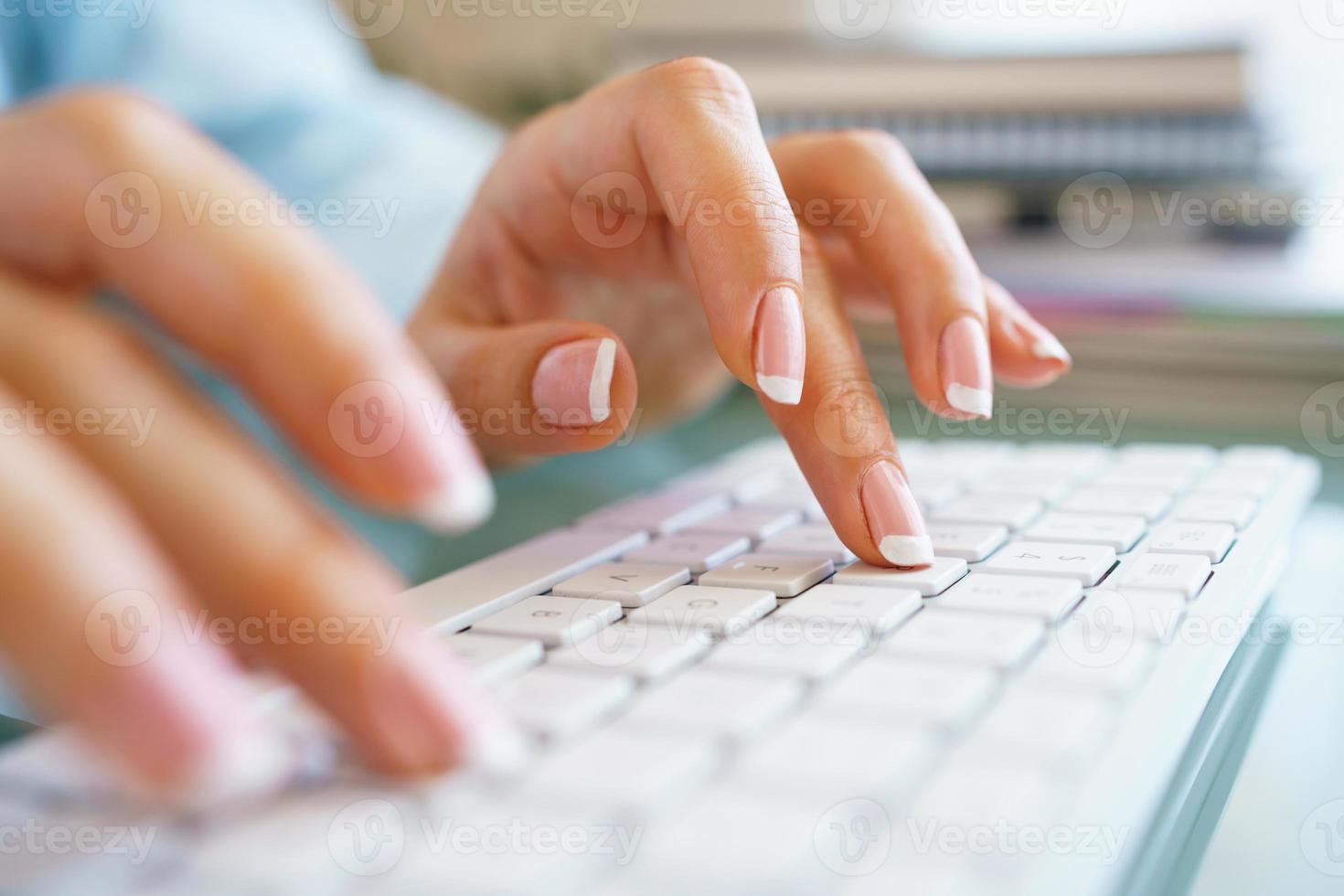 Woman office worker typing on the keyboard photo