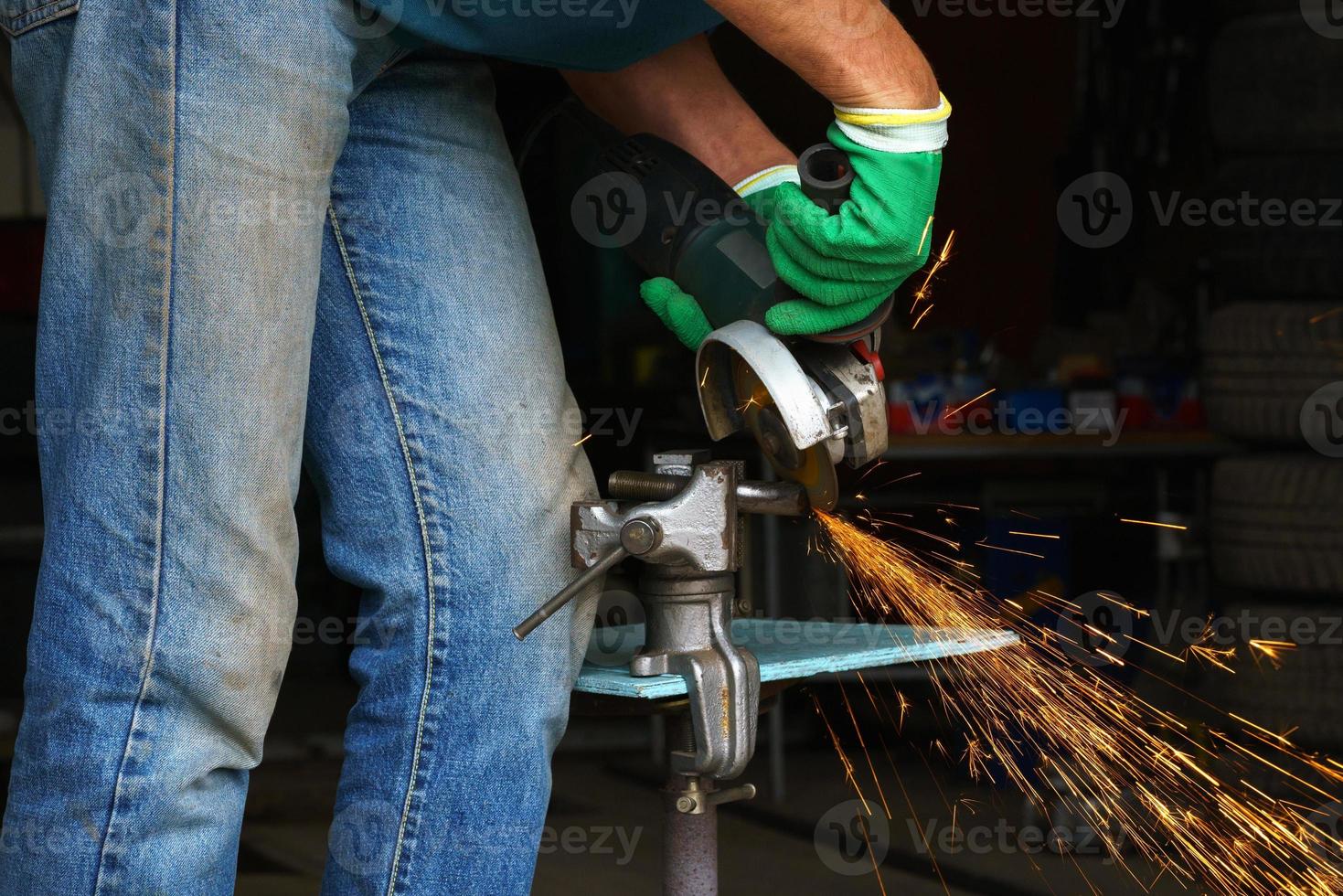Worker with angular grinding machine is cutting the metal photo