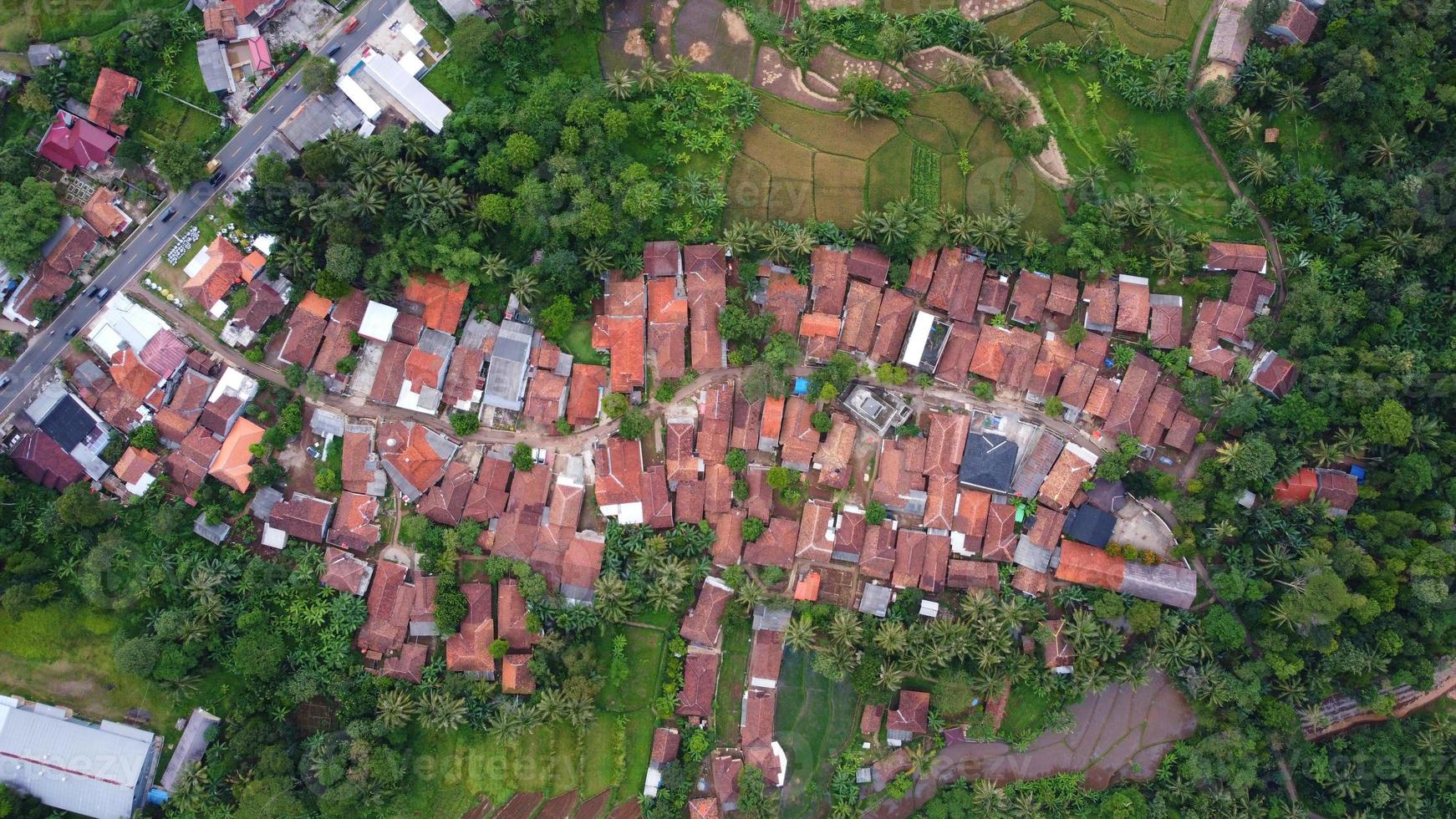 Drone photos from above view of beautiful village houses. Surrounded by lots of trees and close to the main road