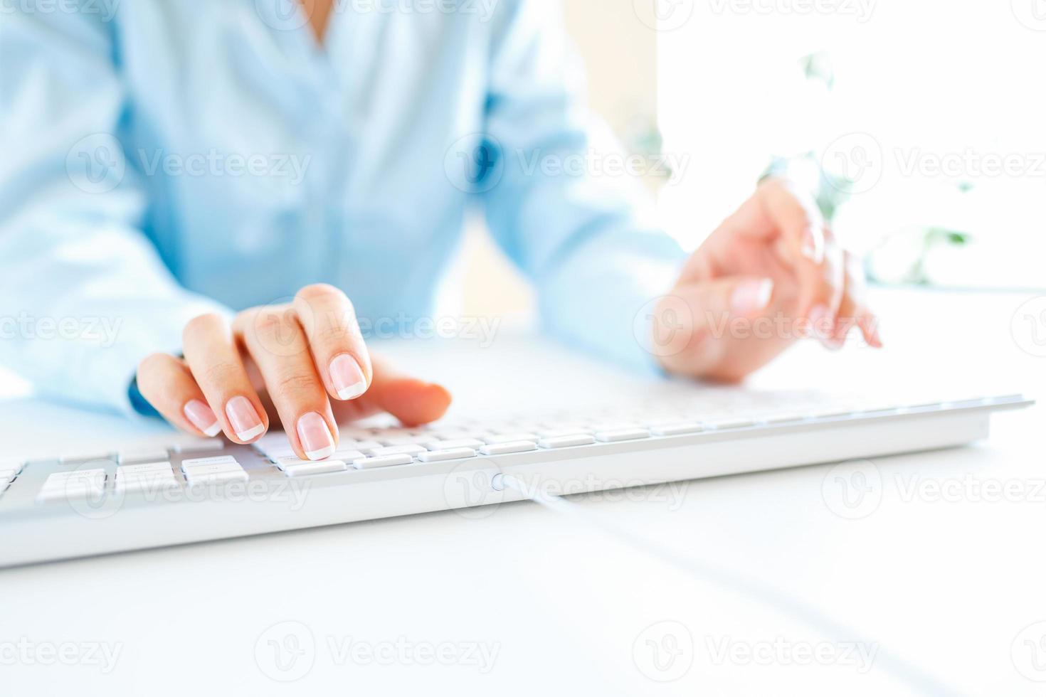 Woman office worker typing on the keyboard photo