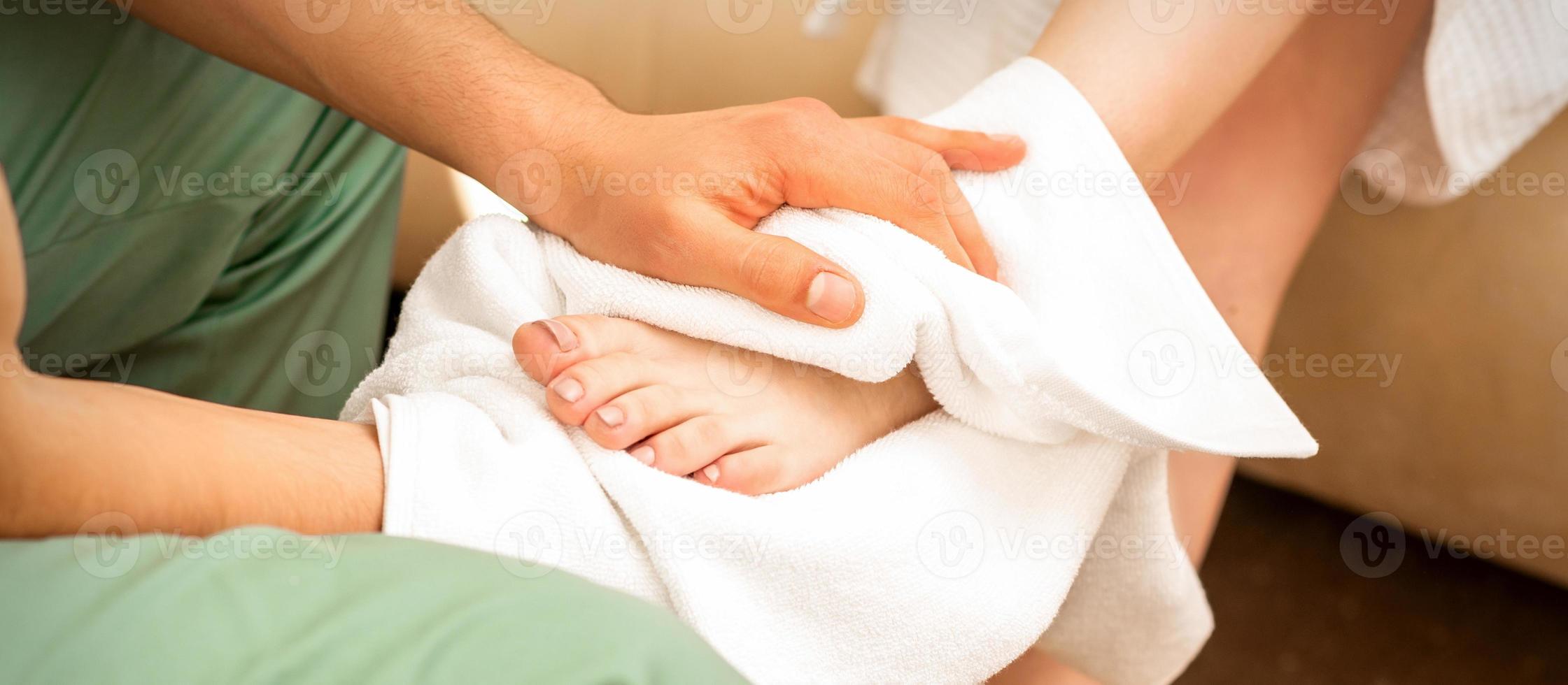 Masseur wiping the woman's legs photo