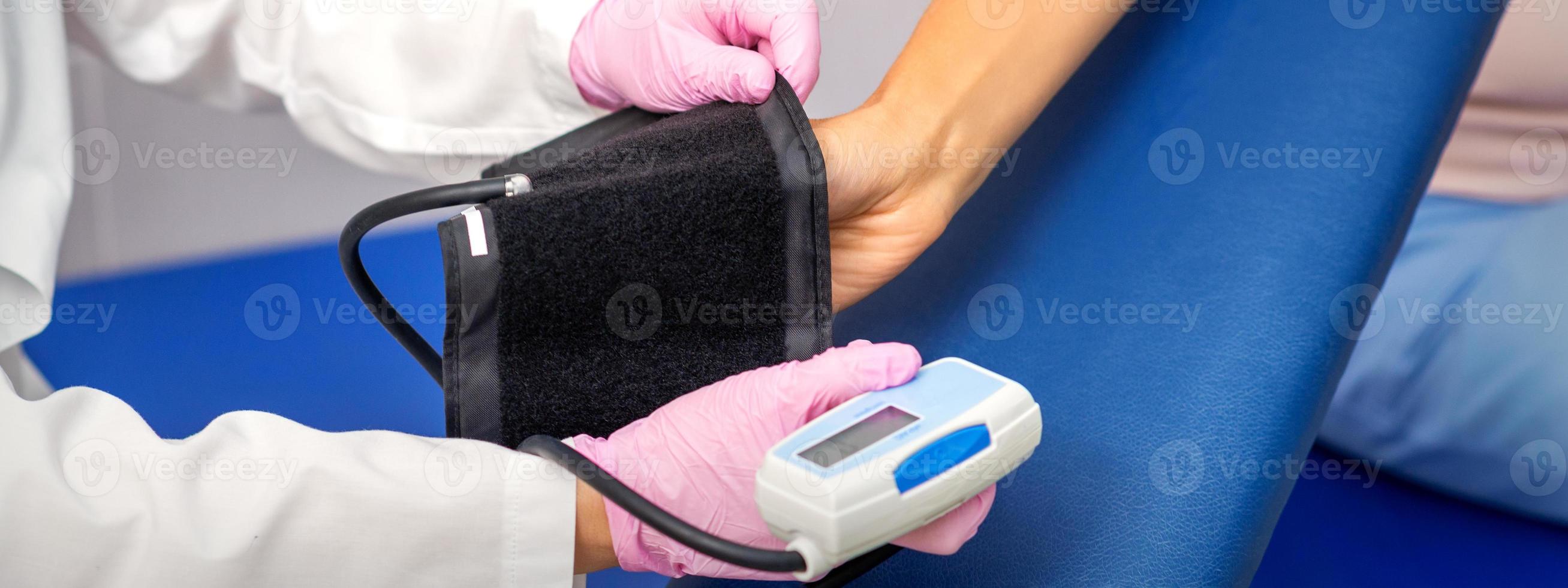 Doctor puts on tonometer on arm photo