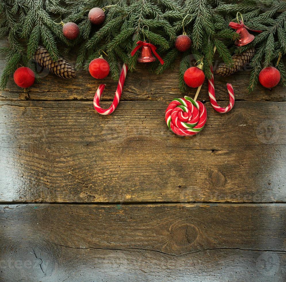 Christmas border with fir tree branches, cones, christmas decorations and candy canes photo