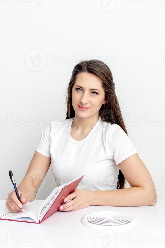 Manicurist writes notes to notebook photo