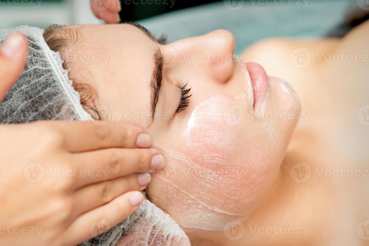 joven mujer consiguiendo facial masaje foto