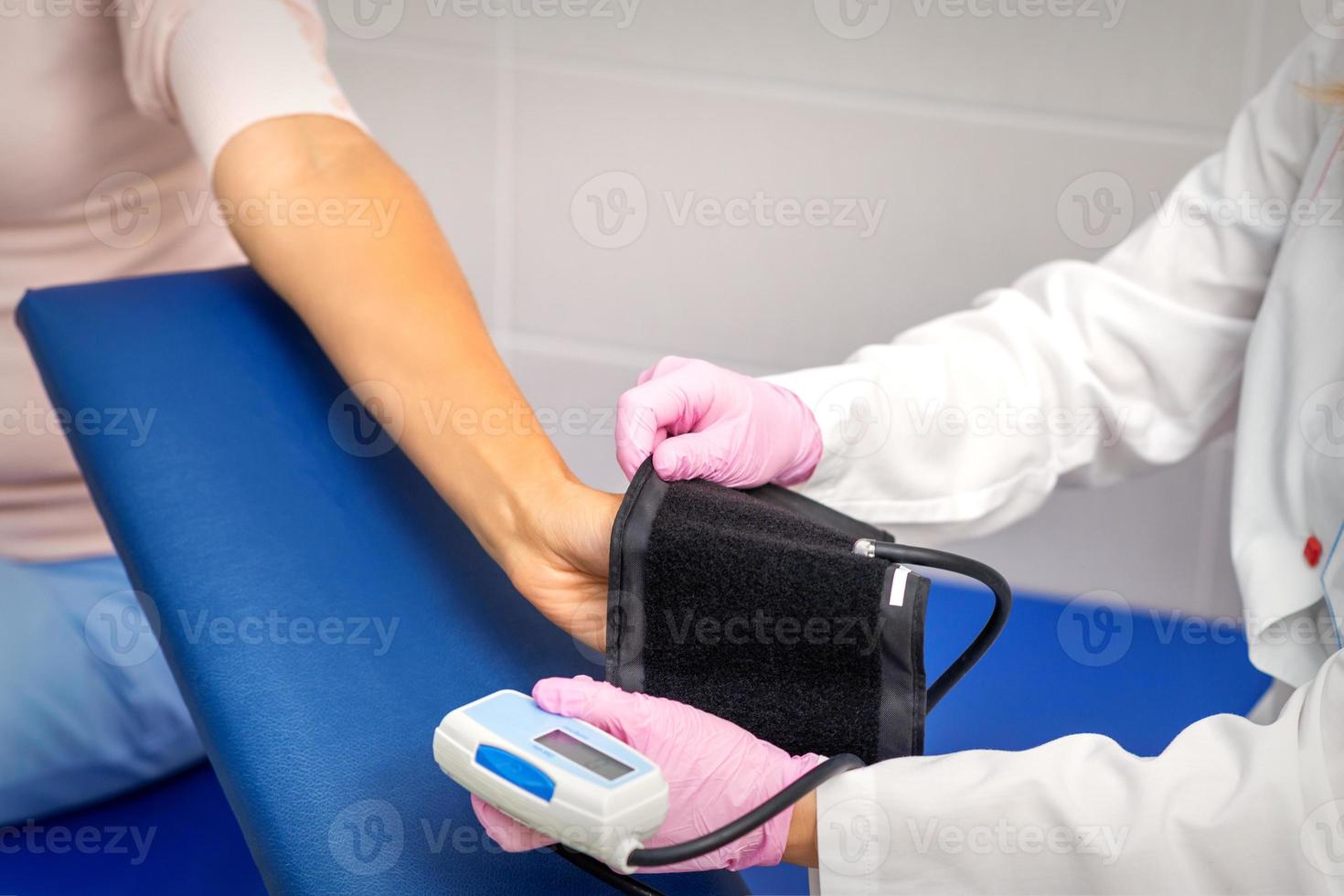 Doctor puts on tonometer on arm photo