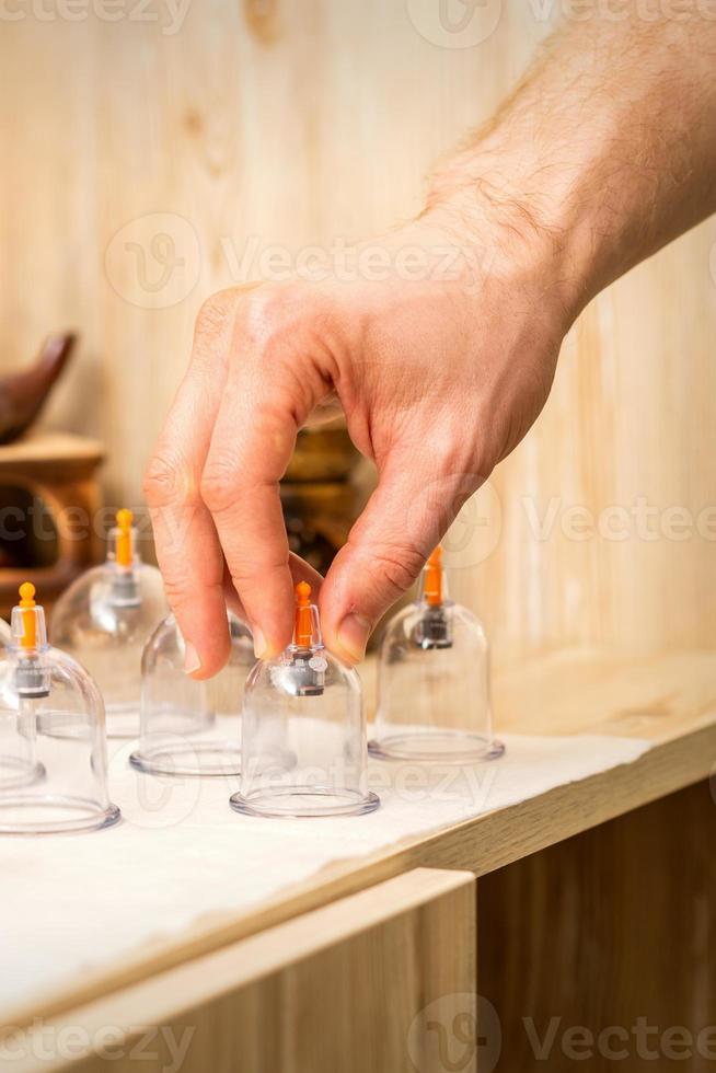 Therapist takes vacuum glass jars photo