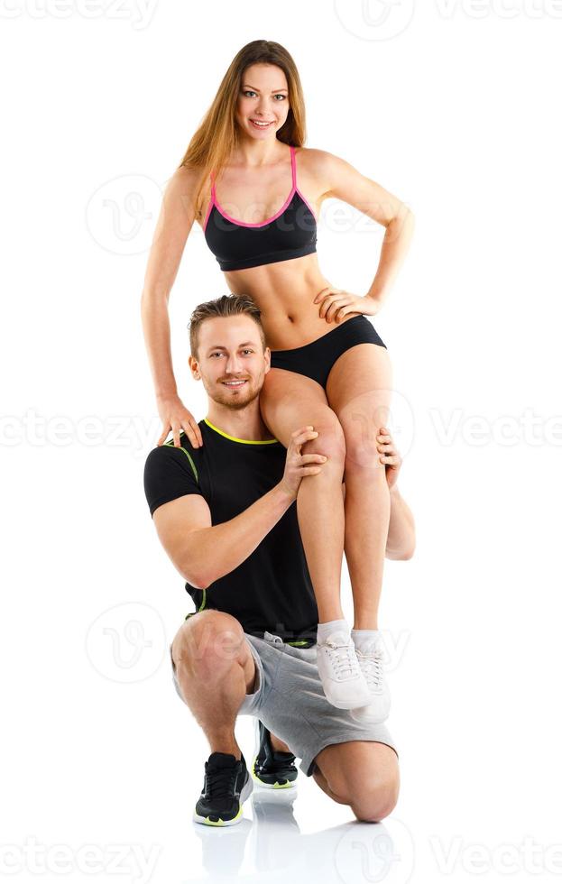 Athletic guy holds on shoulder a girl on a white photo